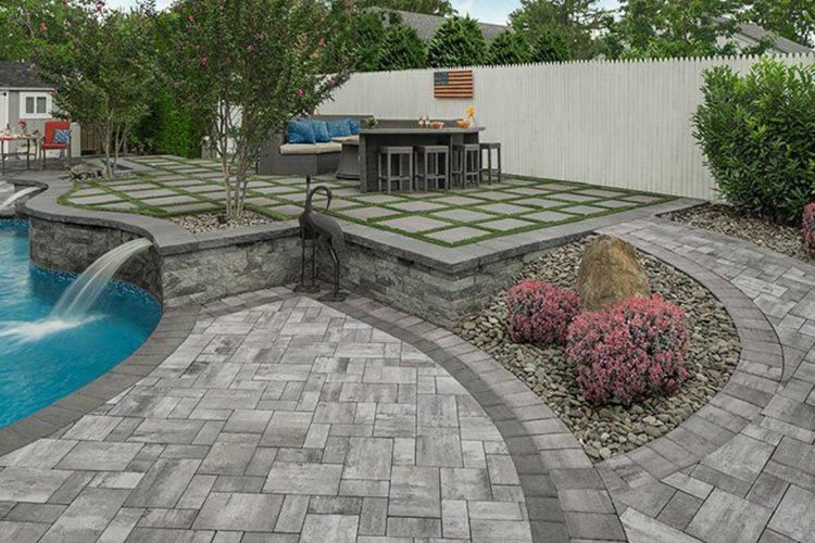 Curved paver stones leading through a meticulously designed backyard with integrated plant beds and seating areas.
