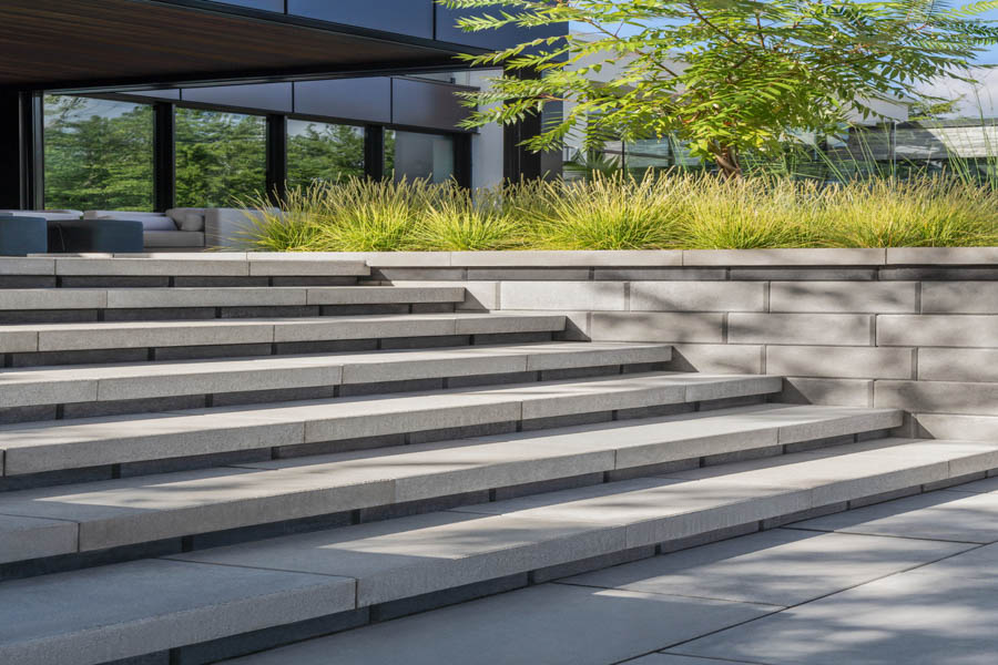 A beautifully landscaped walkway using interlocking concrete pavers, blending functionality with natural beauty.