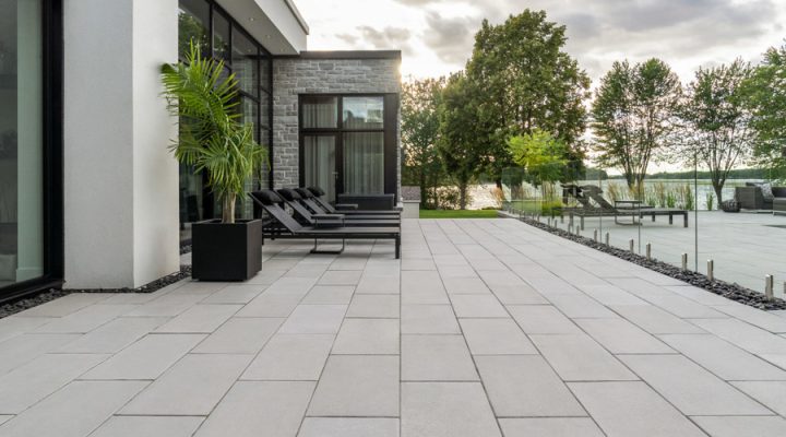 An elegant outdoor living area combining stone walls and a polished concrete floor, perfect for modern homes.